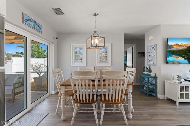 dining area featuring wood finished floors, baseboards, and a chandelier