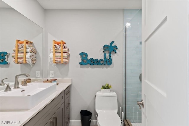bathroom featuring toilet, vanity, and a tile shower