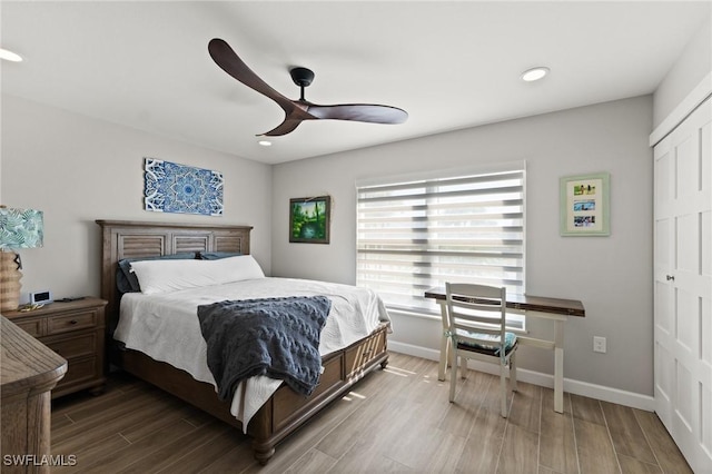 bedroom with wood finished floors, a closet, recessed lighting, baseboards, and ceiling fan