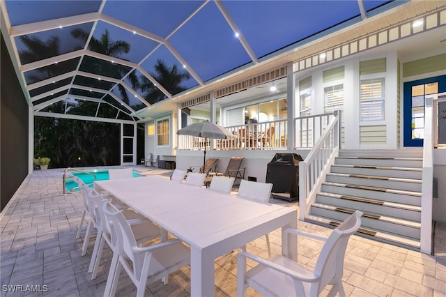 27150 Mora Rd, Bonita Springs, FL 34135 - patio at twilight with a patio area, outdoor dining area, an outdoor pool, glass enclosure, and grilling area