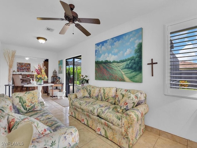 living room featuring tile patterned flooring, a ceiling fan, and baseboards