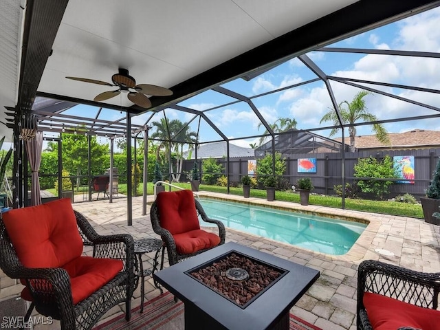 outdoor pool featuring a patio area, ceiling fan, a lanai, fence, and an outdoor living space with a fire pit
