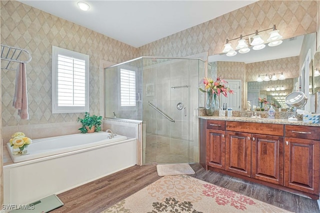 7810 Twin Eagle Ln, Fort Myers, FL 33912 - bathroom with wood finished floors, a bath, vanity, a shower stall, and wallpapered walls