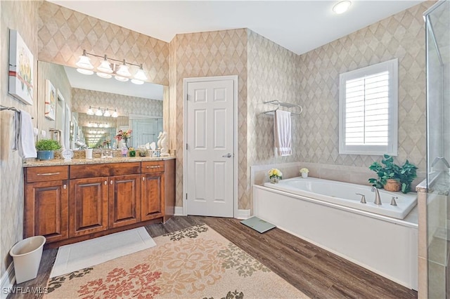 7810 Twin Eagle Ln, Fort Myers, FL 33912 - full bathroom with wood finished floors, a garden tub, vanity, wallpapered walls, and a shower with shower door