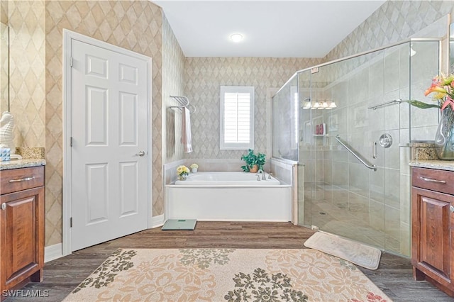 7810 Twin Eagle Ln, Fort Myers, FL 33912 - bathroom featuring wallpapered walls, wood finished floors, vanity, a bath, and a stall shower