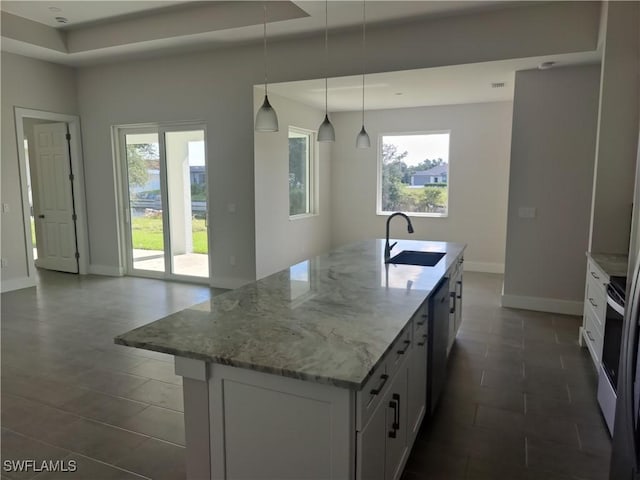 3607 SW 8th Ct, Cape Coral, FL 33914 - kitchen featuring a sink, white cabinetry, baseboards, light stone counters, and plenty of natural light
