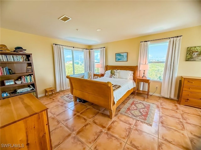 bedroom with light tile patterned flooring and baseboards
