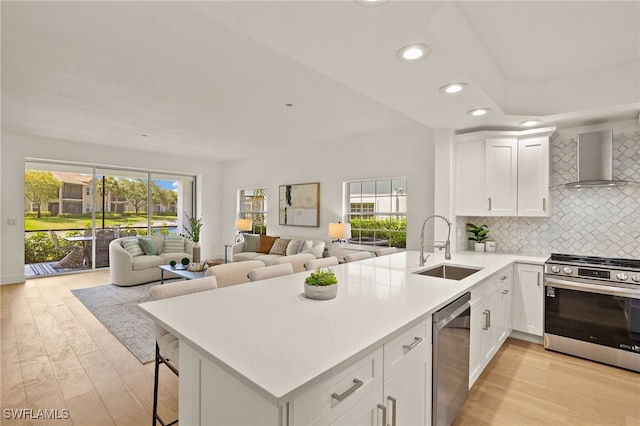 4485 Dover Ct Unit 1202, Naples, FL 34105 - kitchen with stainless steel appliances, wall chimney range hood, a sink, recessed lighting, and open floor plan