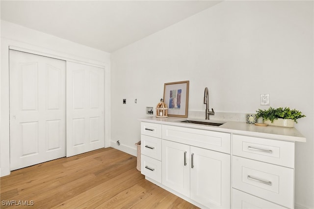 4485 Dover Ct Unit 1202, Naples, FL 34105 - bar area featuring a sink, light wood finished floors, and baseboards