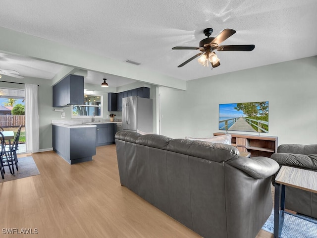 1616 S Hermitage Rd, Fort Myers, FL 33919 - living area featuring a ceiling fan, light wood-type flooring, and a textured ceiling