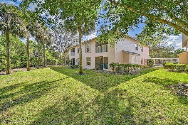 26735 Little John Ct Unit 25, Bonita Springs, FL 34135 - rear view of house featuring stucco siding and a lawn