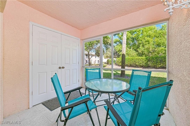 26735 Little John Ct Unit 25, Bonita Springs, FL 34135 - sunroom featuring a textured wall, a textured ceiling, and outdoor dining space