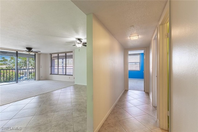3460 N Key Dr Unit 210, North Fort Myers, FL 33903 - hall with a textured ceiling, light tile patterned flooring, light carpet, and baseboards