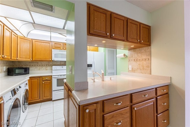 3460 N Key Dr Unit 210, North Fort Myers, FL 33903 - kitchen with white appliances, independent washer and dryer, brown cabinets, decorative backsplash, and a sink