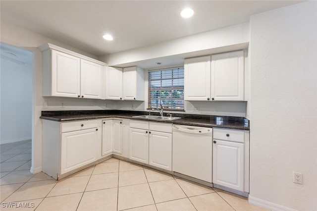 kitchen with white dishwasher, a sink, white cabinetry, light tile patterned flooring, and dark countertops