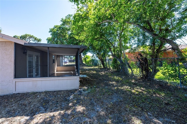 view of yard with french doors and fence