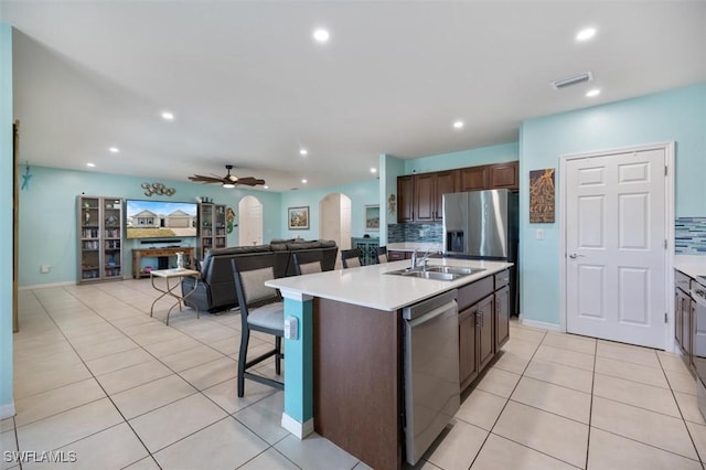 1713 NW 9th Ter, Cape Coral, FL 33993 - kitchen featuring stainless steel appliances, arched walkways, light countertops, tasteful backsplash, and recessed lighting
