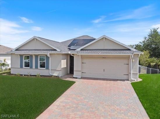 1713 NW 9th Ter, Cape Coral, FL 33993 - ranch-style house featuring stucco siding, decorative driveway, an attached garage, a front lawn, and solar panels