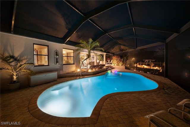 170 June Ct, Marco Island, FL 34145 - pool at night with a patio area, an outdoor pool, and a lanai
