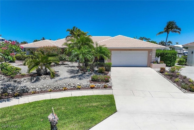 170 June Ct, Marco Island, FL 34145 - view of front of home featuring an attached garage, a tiled roof, driveway, and stucco siding