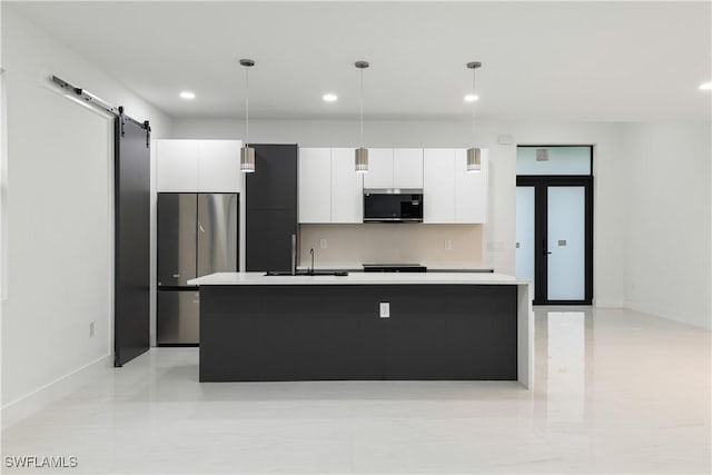 3201 18th St W, Lehigh Acres, FL 33971 - kitchen with stainless steel appliances, a barn door, a sink, white cabinetry, and modern cabinets