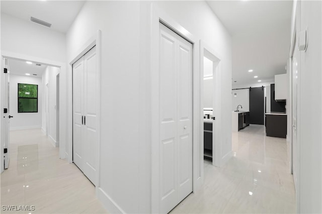 3201 18th St W, Lehigh Acres, FL 33971 - hall with light tile patterned floors, recessed lighting, a sink, a barn door, and baseboards