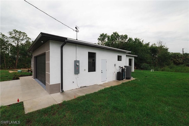3201 18th St W, Lehigh Acres, FL 33971 - view of property exterior with stucco siding, a yard, an attached garage, and driveway