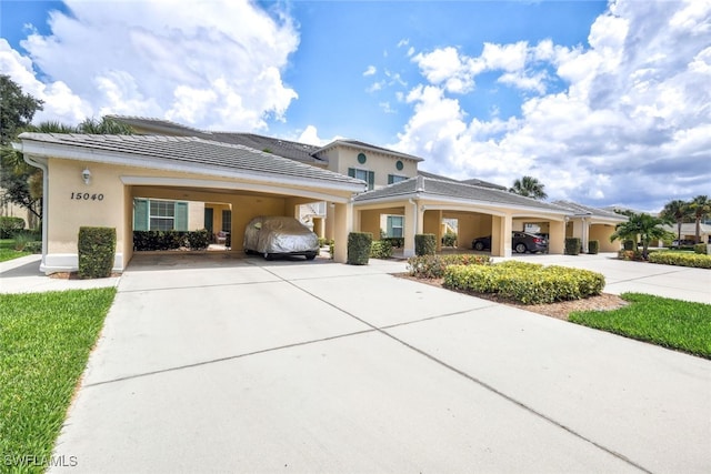 15040 Sandpiper Preserve Blvd Unit 201, Fort Myers, FL 33919 - view of front facade with concrete driveway, stucco siding, a carport, and a tiled roof