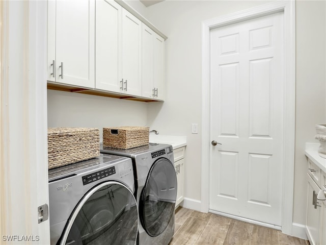 16289 Camden Lakes Cir, Naples, FL 34110 - washroom featuring cabinet space, washing machine and dryer, light wood finished floors, and baseboards