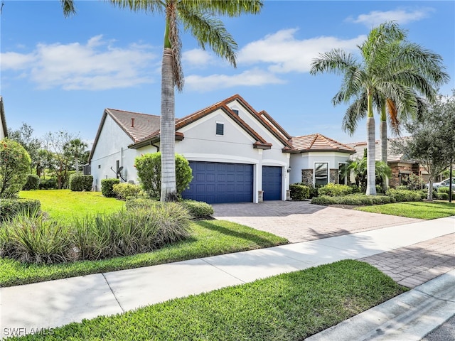 16289 Camden Lakes Cir, Naples, FL 34110 - view of front of property featuring decorative driveway, an attached garage, stucco siding, and a front lawn