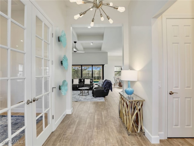16289 Camden Lakes Cir, Naples, FL 34110 - hallway featuring a chandelier, wood finished floors, french doors, and baseboards