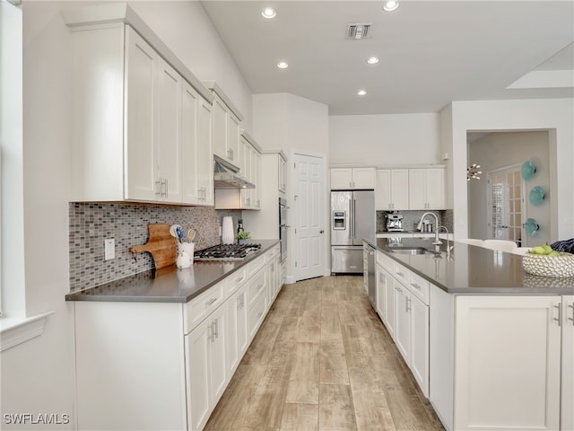 16289 Camden Lakes Cir, Naples, FL 34110 - kitchen with appliances with stainless steel finishes, a sink, dark countertops, under cabinet range hood, and recessed lighting