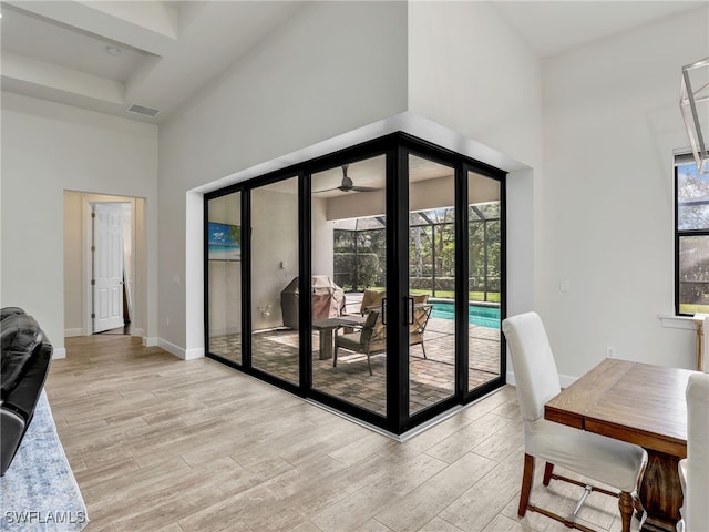 16289 Camden Lakes Cir, Naples, FL 34110 - living area featuring a high ceiling, light wood-type flooring, ceiling fan, and baseboards