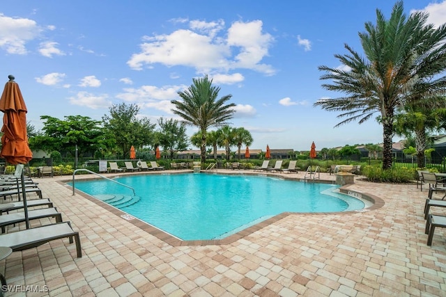 16289 Camden Lakes Cir, Naples, FL 34110 - community pool featuring a patio and fence