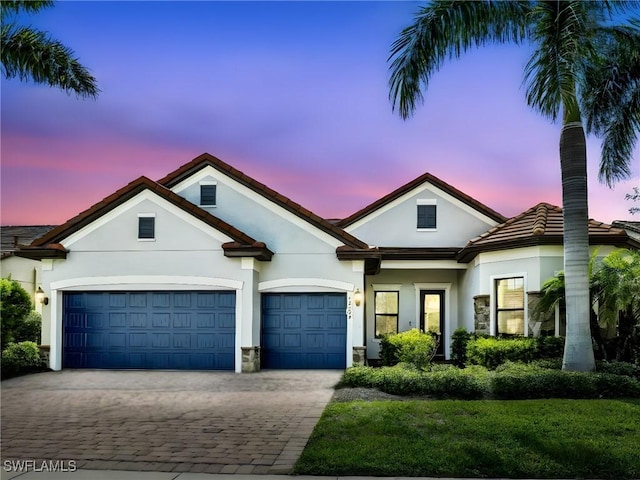 16289 Camden Lakes Cir, Naples, FL 34110 - view of front of home with stucco siding, decorative driveway, a garage, and a tile roof