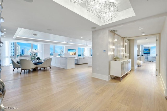 6897 Grenadier Blvd Unit 601, Naples, FL 34108 - living room featuring a raised ceiling, a chandelier, light wood-style flooring, and baseboards