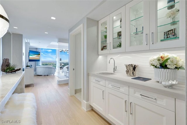 6897 Grenadier Blvd Unit 601, Naples, FL 34108 - bar featuring a sink, light wood finished floors, decorative backsplash, recessed lighting, and baseboards