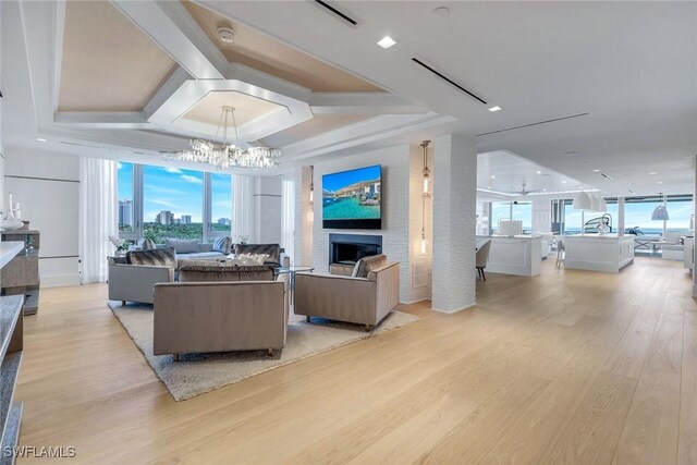 6897 Grenadier Blvd Unit 601, Naples, FL 34108 - living room featuring a fireplace, light wood-style floors, and a chandelier