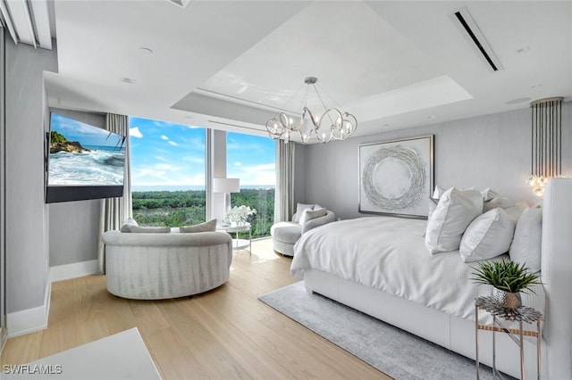 6897 Grenadier Blvd Unit 601, Naples, FL 34108 - bedroom with a tray ceiling, wood finished floors, a chandelier, floor to ceiling windows, and baseboards