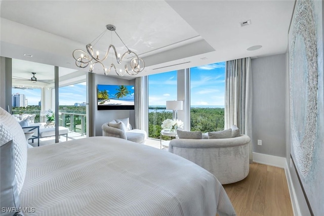 6897 Grenadier Blvd Unit 601, Naples, FL 34108 - bedroom with wood finished floors, multiple windows, access to outside, baseboards, and a wall of windows