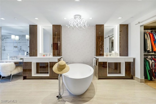 6897 Grenadier Blvd Unit 601, Naples, FL 34108 - bathroom featuring a freestanding tub, a chandelier, a walk in closet, and two vanities