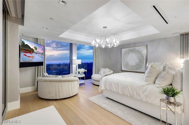 6897 Grenadier Blvd Unit 601, Naples, FL 34108 - bedroom with a tray ceiling, wood finished floors, a chandelier, and baseboards