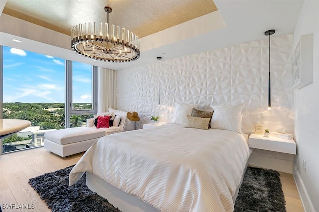 6897 Grenadier Blvd Unit 601, Naples, FL 34108 - bedroom featuring wood finished floors, a chandelier, and baseboards