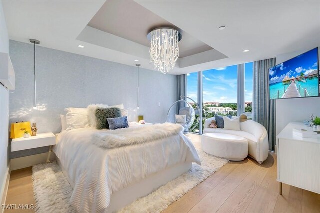 6897 Grenadier Blvd Unit 601, Naples, FL 34108 - bedroom with light wood finished floors, expansive windows, a chandelier, a tray ceiling, and recessed lighting