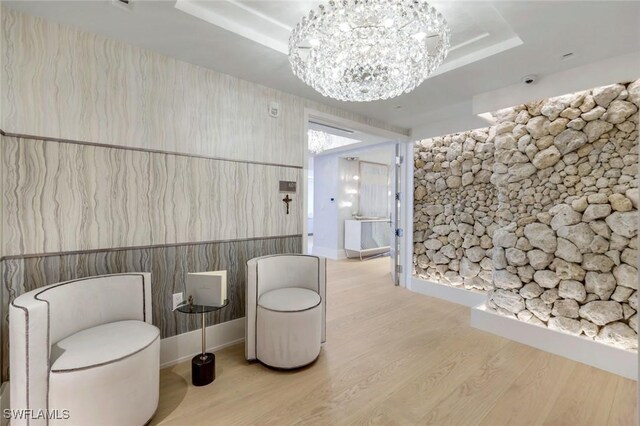 6897 Grenadier Blvd Unit 601, Naples, FL 34108 - sitting room featuring a chandelier, light wood finished floors, and a tray ceiling