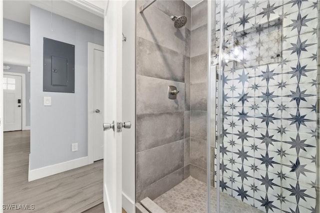 222 Mango St, Fort Myers Beach, FL 33931 - bathroom featuring electric panel, wood finished floors, a tile shower, and baseboards