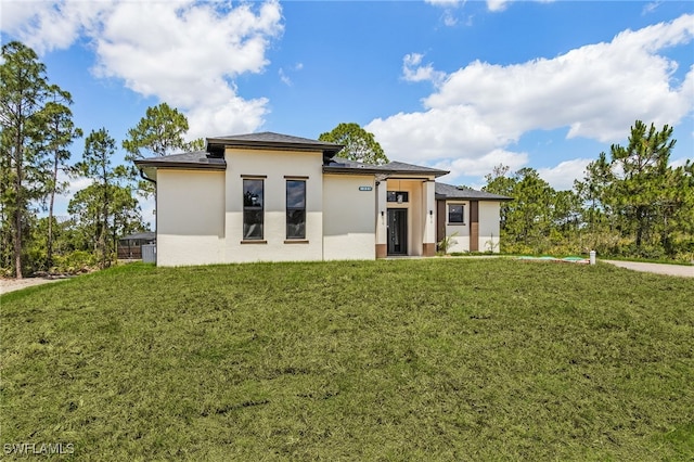 956 Columbus Blvd S, Lehigh Acres, FL 33974 - view of front of house with stucco siding and a front yard