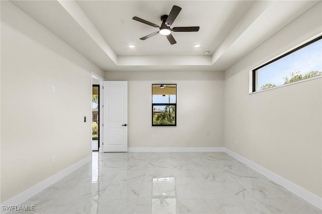 956 Columbus Blvd S, Lehigh Acres, FL 33974 - empty room featuring plenty of natural light, a ceiling fan, a raised ceiling, baseboards, and recessed lighting
