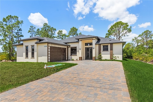 956 Columbus Blvd S, Lehigh Acres, FL 33974 - prairie-style home featuring stucco siding, an attached garage, french doors, and a front yard