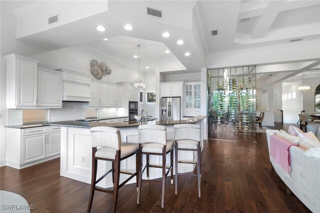 10692 Mirasol Dr Unit 1004, Miromar Lakes, FL 33913 - kitchen with black appliances, dark countertops, a chandelier, ornamental molding, and a large island with sink